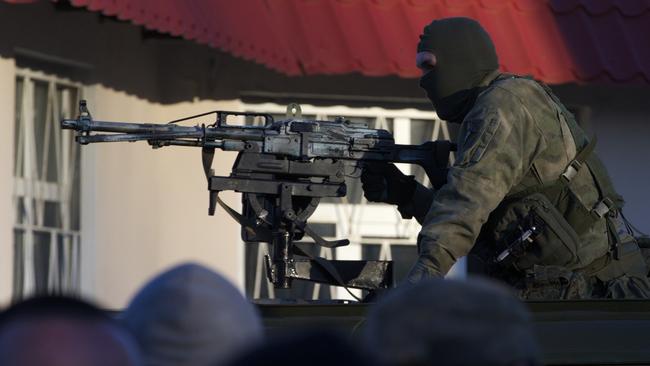 A Russian machine gunner controls the gate of the Belbek air base, outside Sevastopol, Crimea. Picture; AP.