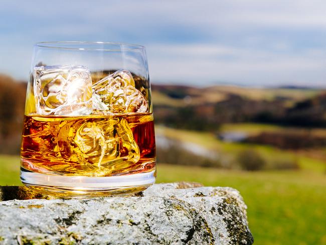 Glass of whisky on the rocks in the Scottish Highlands.