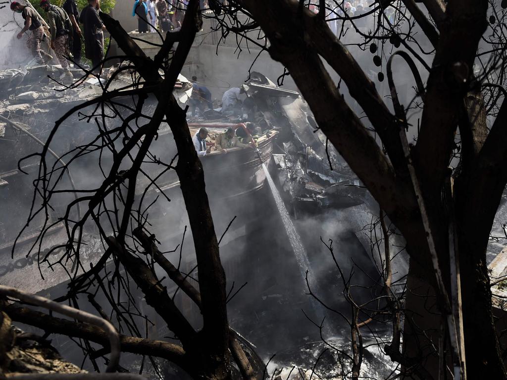 Firefighters spray water on the wreckage of a Pakistan International Airlines aircraft after it crashed in a residential area in Karachi. Picture: AFP