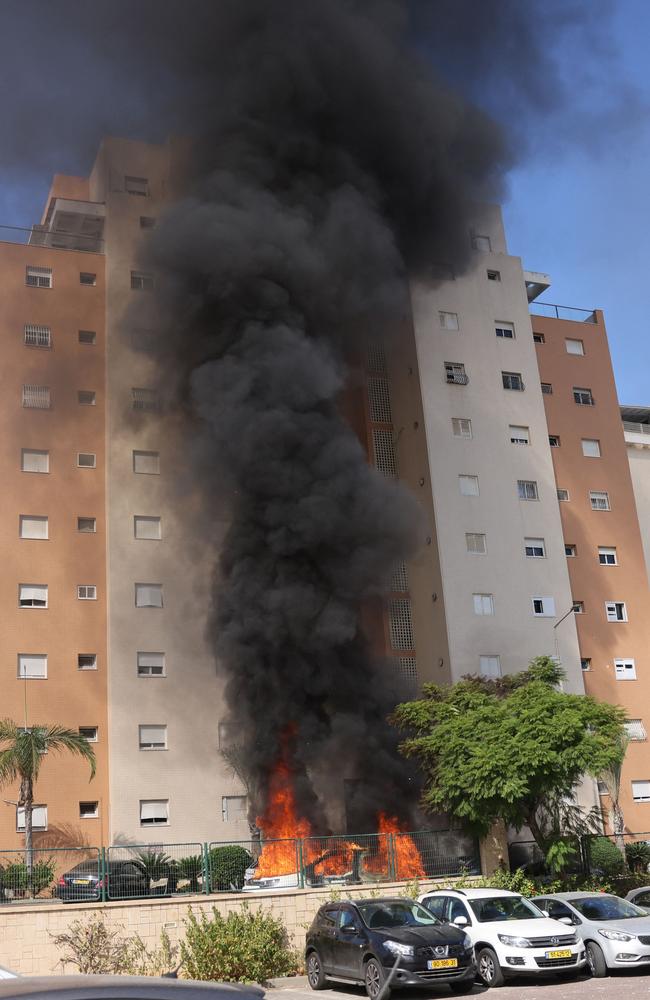 Cars catch fire outside a residential building following a rocket attack from the Gaza Strip in the southern Israeli city of Ashkelon. Picture: AFP