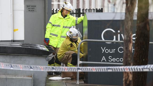 Firefighters cutting open the charity bin. Picture: Glenn Hampson