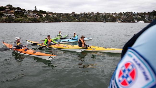 Maritime NSW officer Rianna James talks to kayaker Tom Sherlock and his group of friends.