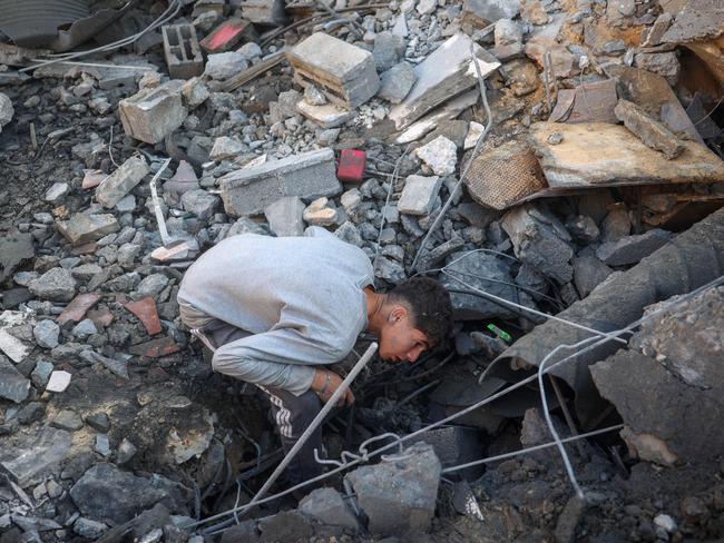 A youth searches for survivors at the site of an Israeli strike that targeted the Abu Samra family home in Deir el-Balah in the central Gaza Strip. Picture: AFP