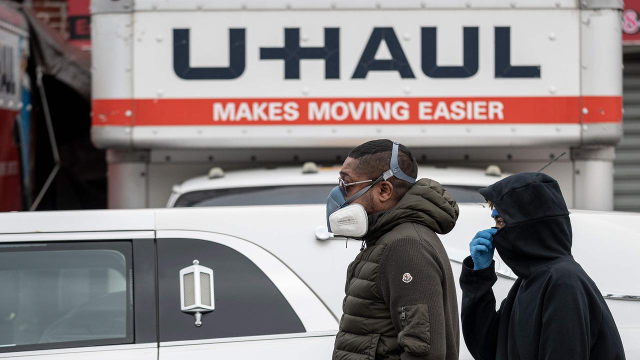 Onlookers with masks walk outside a funeral home in Brooklyn on April 30, 2020 in New York City. Picture: Johannes Eisele/AFP