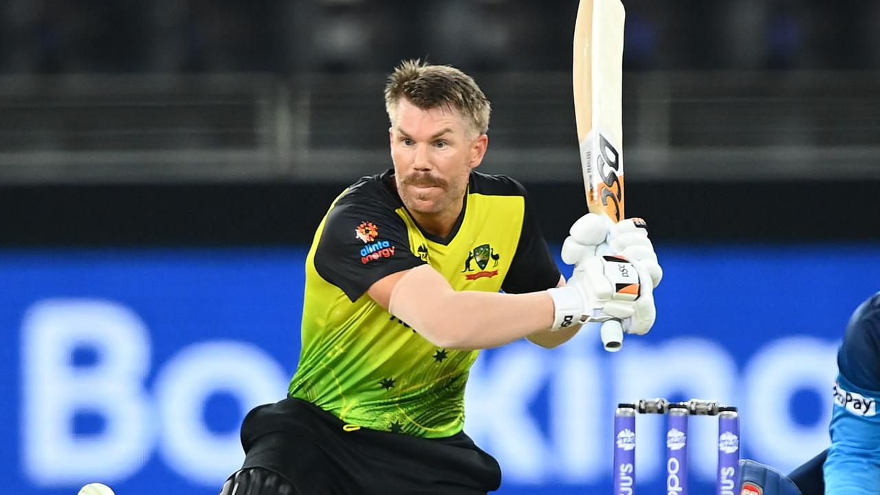 DUBAI, UNITED ARAB EMIRATES - OCTOBER 28: David Warner of Australia plays a shot as Kusal Perera of Sri Lanka looks on during the ICC Men's T20 World Cup match between Australia and Sri Lanka at Dubai International Stadium on October 28, 2021 in Dubai, United Arab Emirates. (Photo by Alex Davidson/Getty Images)