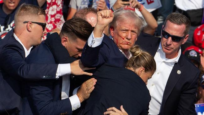 US Republican candidate Donald Trump is seen with blood on his face surrounded by secret service agents.