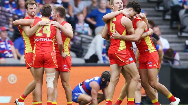 Gold Coast players celebrate their win against the Western Bulldogs.