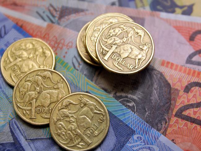 Australian one-dollar coins sit with a collection of banknotes arranged for a photograph, in Sydney, Australia, on Wednesday, Aug. 3, 2011. Australia's central bank may need to resume increasing the developed world's highest borrowing costs to keep inflation from accelerating as a mining boom intensifies, according to the International Monetary Fund. Photographer: Sergio Dionisio/Bloomberg