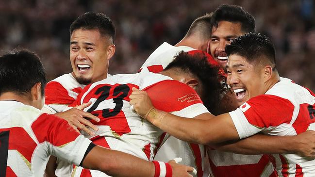 Japan players celebrate making it to the knockout stages of the Rugby World Cup for the first time. Picture: Cameron Spencer/Getty Images