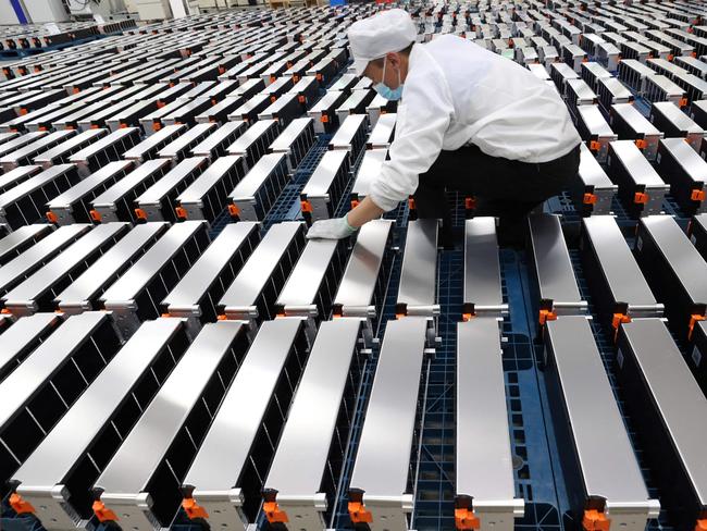 (FILES) This file photo taken on March 12, 2021 shows a worker with car batteries at a factory for Xinwangda Electric Vehicle Battery Co. Ltd, which makes lithium batteries for electric cars and other uses, in Nanjing in China's eastern Jiangsu province. - Lithium, cobalt and nickel, the metals that are essential to the manufacture of the electric batteries that will replace the combustion engines that contribute to global warming, are so sought after that Europe is preparing to open mines and refineries to try to reduce its dependence on imports. (Photo by AFP) / China OUT