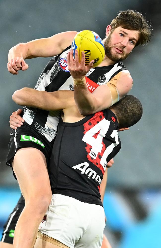 Rupert Wills handballs while tackled by Adam Saad. Picture: Quinn Rooney/Getty Images