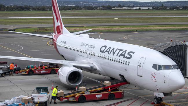 ADELAIDE, AUSTRALIA - NewsWire Photos August 10, 2022: Baggage handlers load luggage on a Qantas aircraft at Adelaide Airport.Qantas will increase the waiting time between domestic to international connecting flights by 30 minutes in an effort to mitigate the number of people arriving at their destination without their luggage and has asked executives to work as baggage handlers for three months. Picture: NCA NewsWire