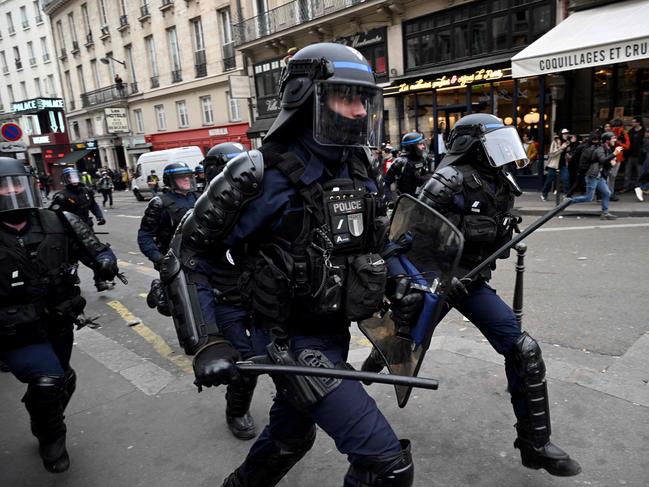 French riot police officers run towards protestors during a demonstration against pension reforms, in Paris. Picture: AFP