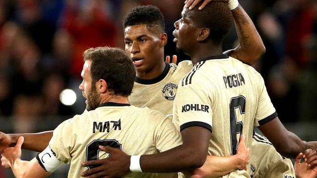 Marcus Rashford (facing) celebrates with teammates Juan Mata and Paul Pogba after he scored Manchester United’s first goal following a nice flick from Pogba. Picture: AAP