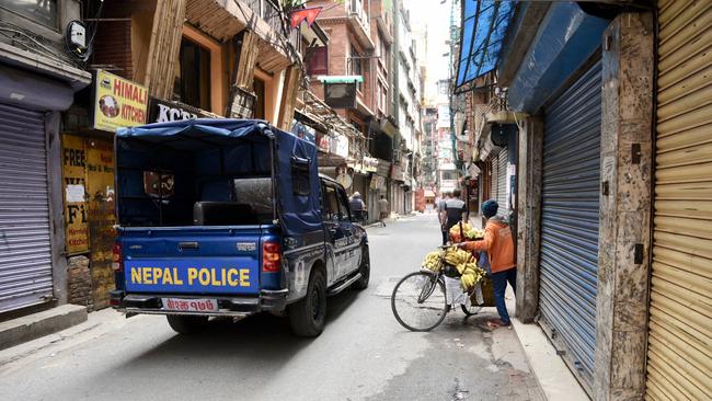 Police remove a fruit vendor from the street as Nepal looks down its streets. Picture: Brad Fleet