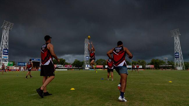 The NTFL rep squad trains at TIO stadium under storm clouds yesterday. Picture: Che Chorley