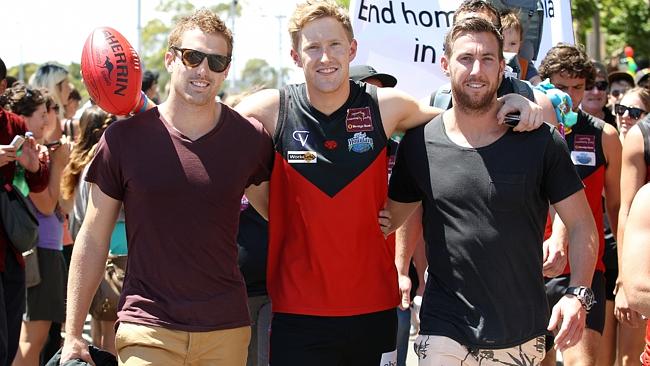 Ball, middle, marches for equality with Richmond player Daniel Jackson (L) and Carlton fo