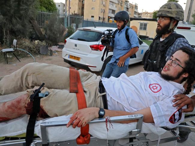 An Israeli far-right extremist is taken away on a stretcher after being wounded during ongoing tensions. Picture: Oren ZIV / AFP