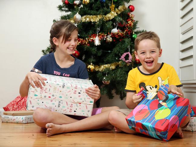 Frankie Berry, 9 and Angus Berry, 6 opening some early Christmas presents at home in Dulwich Hill in Sydney. Picture: Tim Hunter.