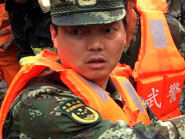 CORRECTION - Chinese military police and rescue workers are seen at the site of a landslide in in Xinmo village, Diexi town of Maoxian county, Sichuan province on June 24, 2017.  Around 100 people are feared buried after a landslide smashed through their village in southwest China's Sichuan Province early Saturday, local officials said, as they launched an emergency rescue operation. / AFP PHOTO / STR / China OUT / “The erroneous mention[s] appearing in the metadata of this photo by STR has been modified in AFP systems in the following manner: [Maoxian] instead of [Maoxiang]. Please immediately remove the erroneous mention[s] from all your online services and delete it (them) from your servers. If you have been authorized by AFP to distribute it (them) to third parties, please ensure that the same actions are carried out by them. Failure to promptly comply with these instructions will entail liability on your part for any continued or post notification usage. Therefore we thank you very much for all your attention and prompt action. We are sorry for the inconvenience this notification may cause and remain at your disposal for any further information you may require.”