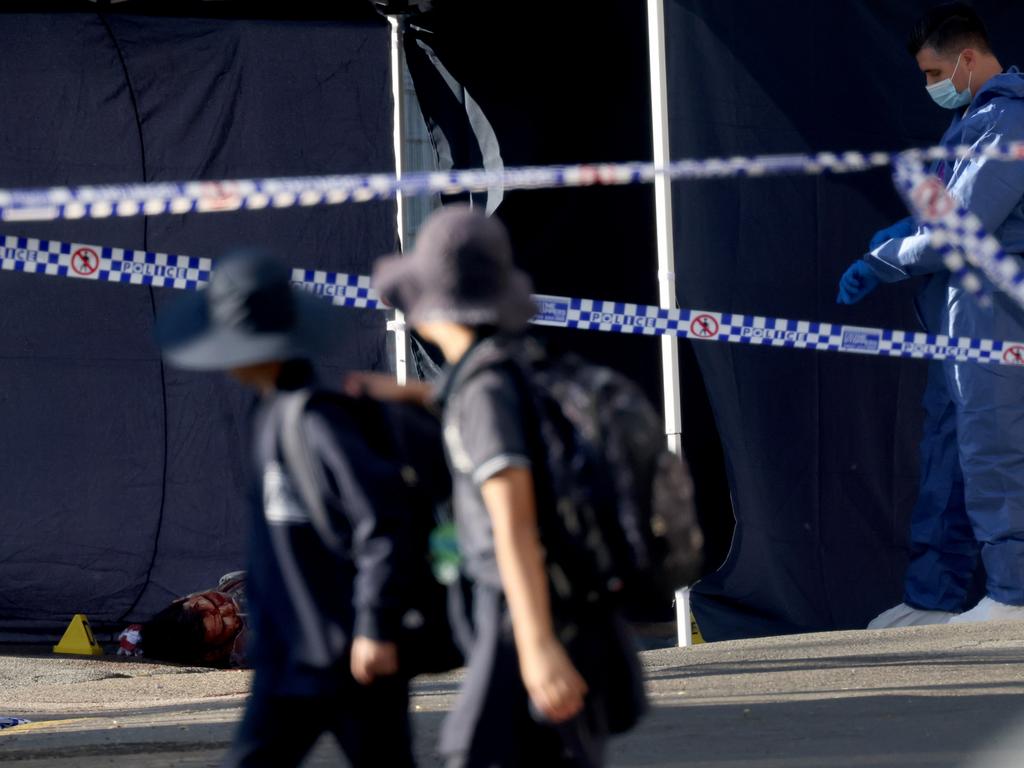 Schoolchildren pass a crime scene with forensics police in Canterbury, NSW, where a man was fatally shot. Picture: Damian Shaw/NCA Newswire