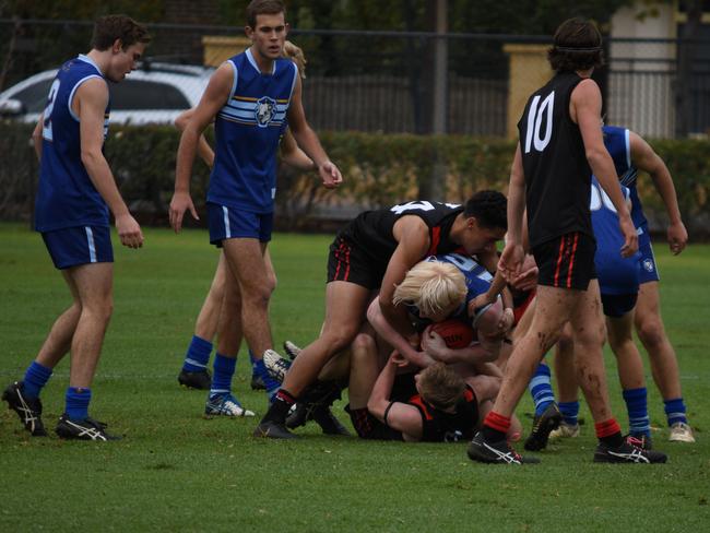 Rostrevor and Sacred Heart footballers pile on during their game on Saturday.