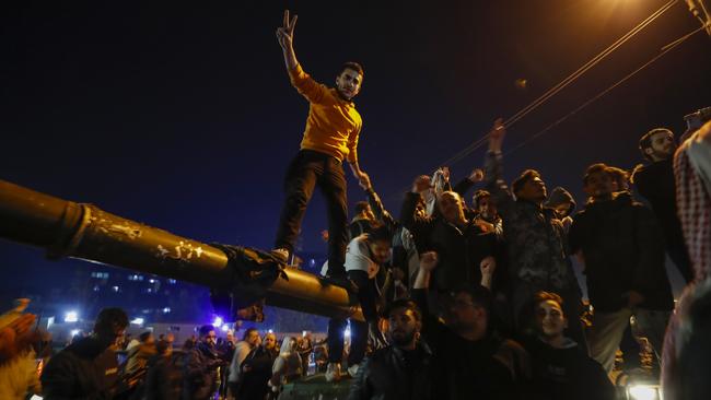 Syrians celebrate the arrival of opposition fighters in Damascus, Syria, on Sunday. Picture: AP