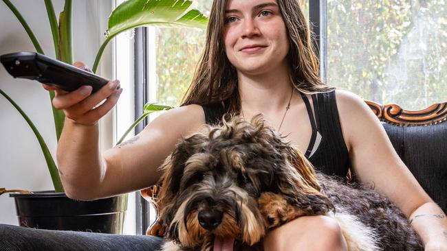 New research shows dogs like to watch TV.  Jade Williams watches TV with her dog Western. Picture: Jake Nowakowski