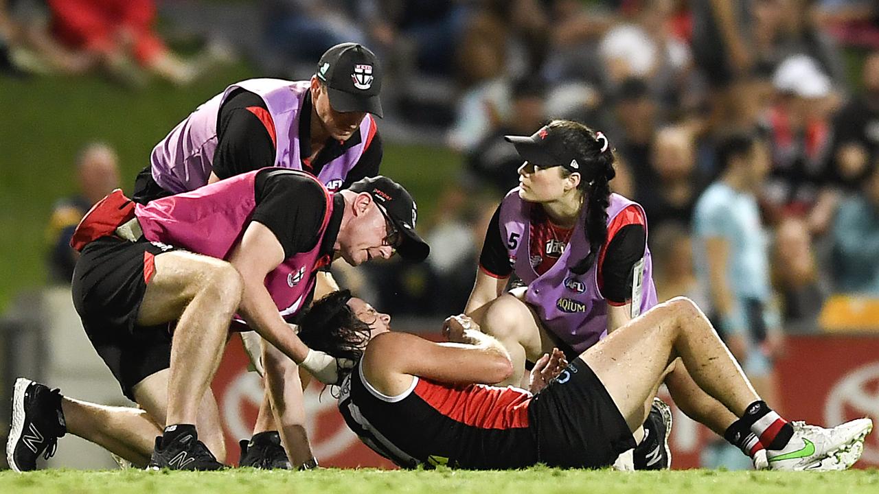 The St Kilda defender in the hands of the trainers after the bone-jarring hit.