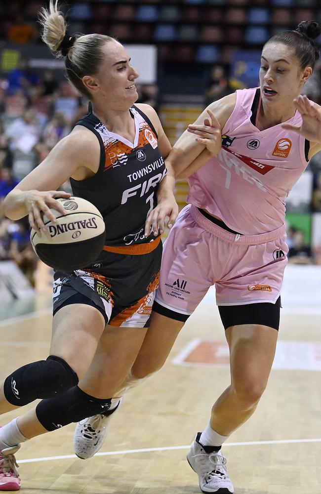 Courtney Woods of the Fire drives to the basket past Emma Clarke of the Flames during the WNBL match between Townsville Fire and Sydney Flames at Townsville Entertainment Centre, on February 25, 2024, in Townsville, Australia. (Photo by Ian Hitchcock/Getty Images)