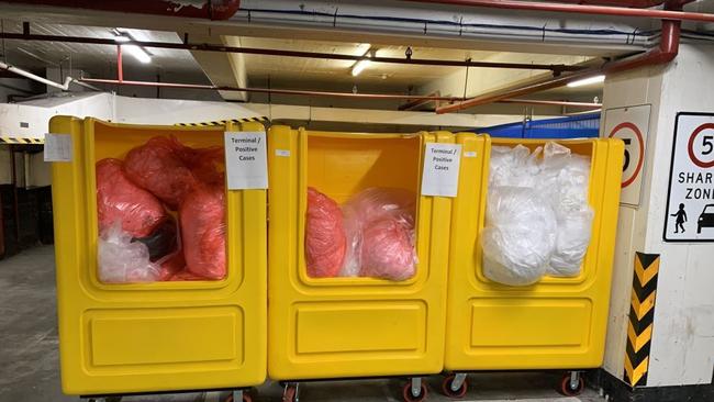 Bins holding rubbish from the Novotel quarantine hotel in the joint carpark shared by the Novotel and 408 Lonsdale St apartment tower.