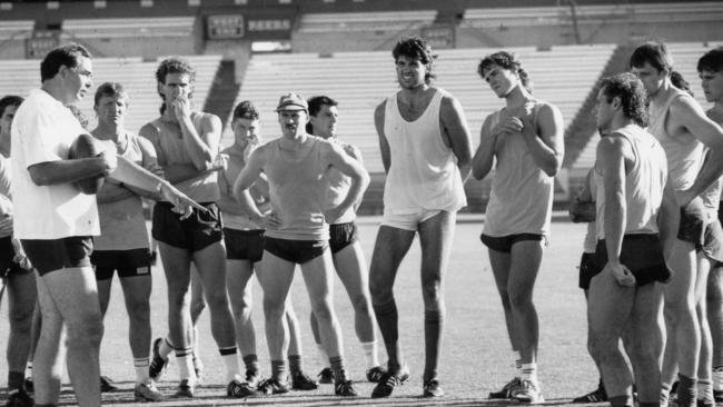  Skills coach Peter Carey gives centre square advice to, from left, Chris McDermott, Mark Mickan, Mark Bickley, Bruce Lindsay, Grant Fielke, Romano Negri, David Pittman, Tony McGuinness, Russell Johnston and Daryl Heath at Adelaide Crows training in February 1991. Picture: Russell Millard