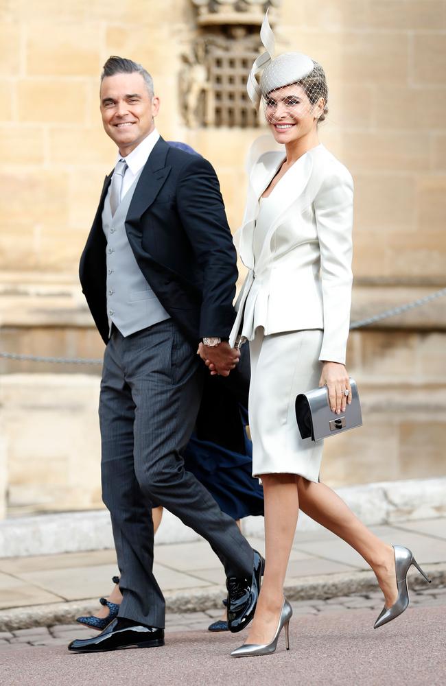 British singer-songwriter Robbie Williams (L) arrives with his wife US actress Ayda Field (R) to attend the wedding of Britain's Princess Eugenie of York to Jack Brooksbank at St George's Chapel, Windsor Castle, in Windsor, on October 12, 2018. (Photo by Alastair Grant / various sources / AFP)