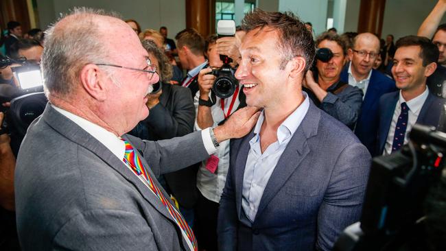 Liberal MP Warren Entsch (L) celebrates with Olympic swimmer Ian Thorpe after parliament passed the same-sex marriage bill.