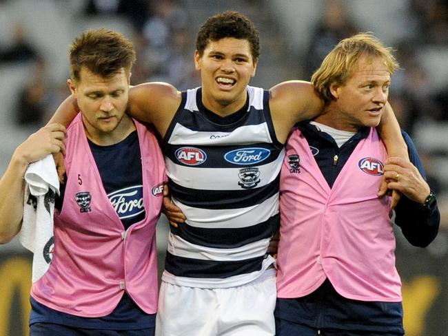 Brandan Parfitt of the Cats is assisted off the ground, during the Round 6 AFL match between the Geelong Cats and the Collingwood Magpies at the MCG in Melbourne, Sunday, April 30, 2017. (AAP Image/Joe Castro) NO ARCHIVING, EDITORIAL USE ONLY