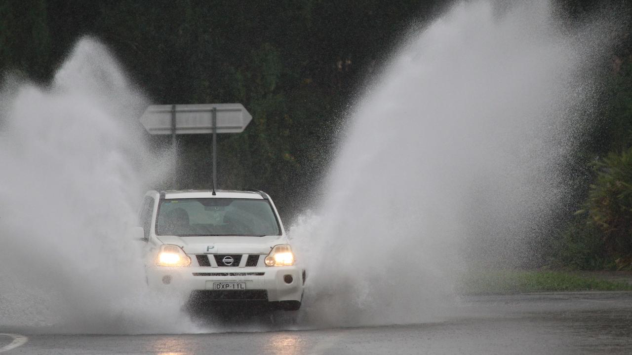 A car driving through rising waters after torrential rain hit the Gold Coast. Picture: Mike Batterham