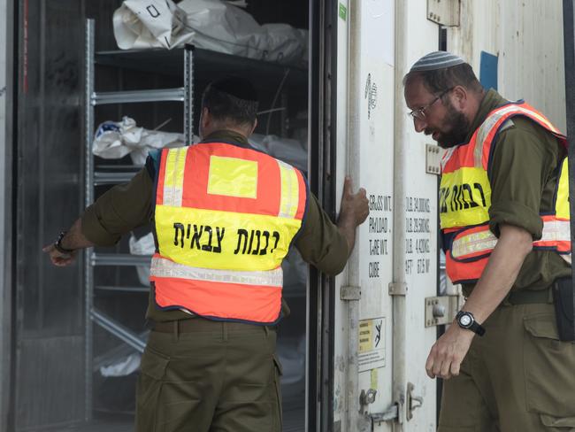 Soldiers of the Military Rabbinate unit open a container filled with bodies of the people killed during at the Hamas attack on the Israeli southern border. Picture: Getty Images