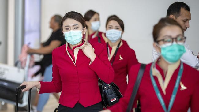 Passengers wear face masks to protect themselves from potential coronavirus at Brisbane International Airport. Picture: AAP