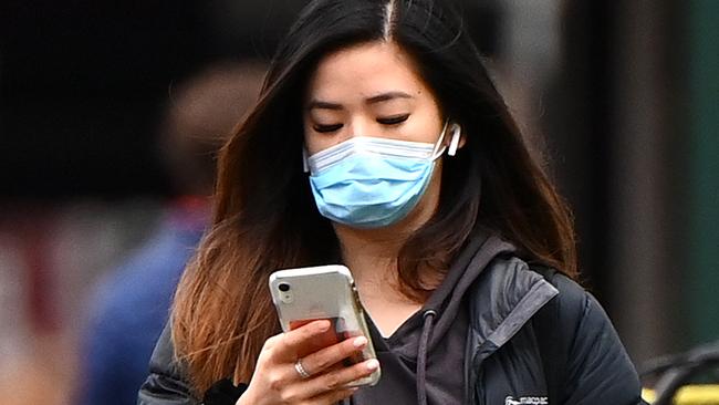 MELBOURNE, AUSTRALIA - JULY 20: A woman wearing a face mask walks through the city on July 20, 2020 in Melbourne, Australia. Victoria has recorded 275 new cases of coronavirus, and another death overnight. The death of the woman in her 80s brings the total number of deaths linked to COVID-19 in the state to 39. Metropolitan Melbourne and the Mitchell shire remain in lockdown due to the rise in COVID-19 cases through community transmissions, with residents in lockdown areas under stay at home orders until 19 August. People are only able to leave home have for exercise or work, to buy essential items including food or to access childcare and healthcare. Face masks or coverings will be mandatory from Thursday 23 July, with $200 fines to apply for not wearing face coverings.  (Photo by Quinn Rooney/Getty Images)