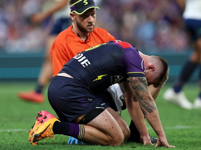 BRISBANE, AUSTRALIA - MAY 19: Cameron Munster of the Storm receives attention from the trainer during the round 11 NRL match between Melbourne Storm and Parramatta Eels at Suncorp Stadium, on May 19, 2024, in Brisbane, Australia. (Photo by Hannah Peters/Getty Images)