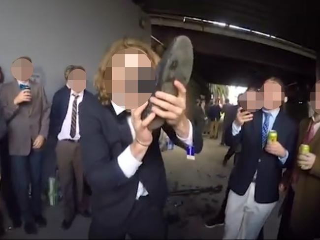 A student performing a ‘shoey’ — drinking from his footwear.