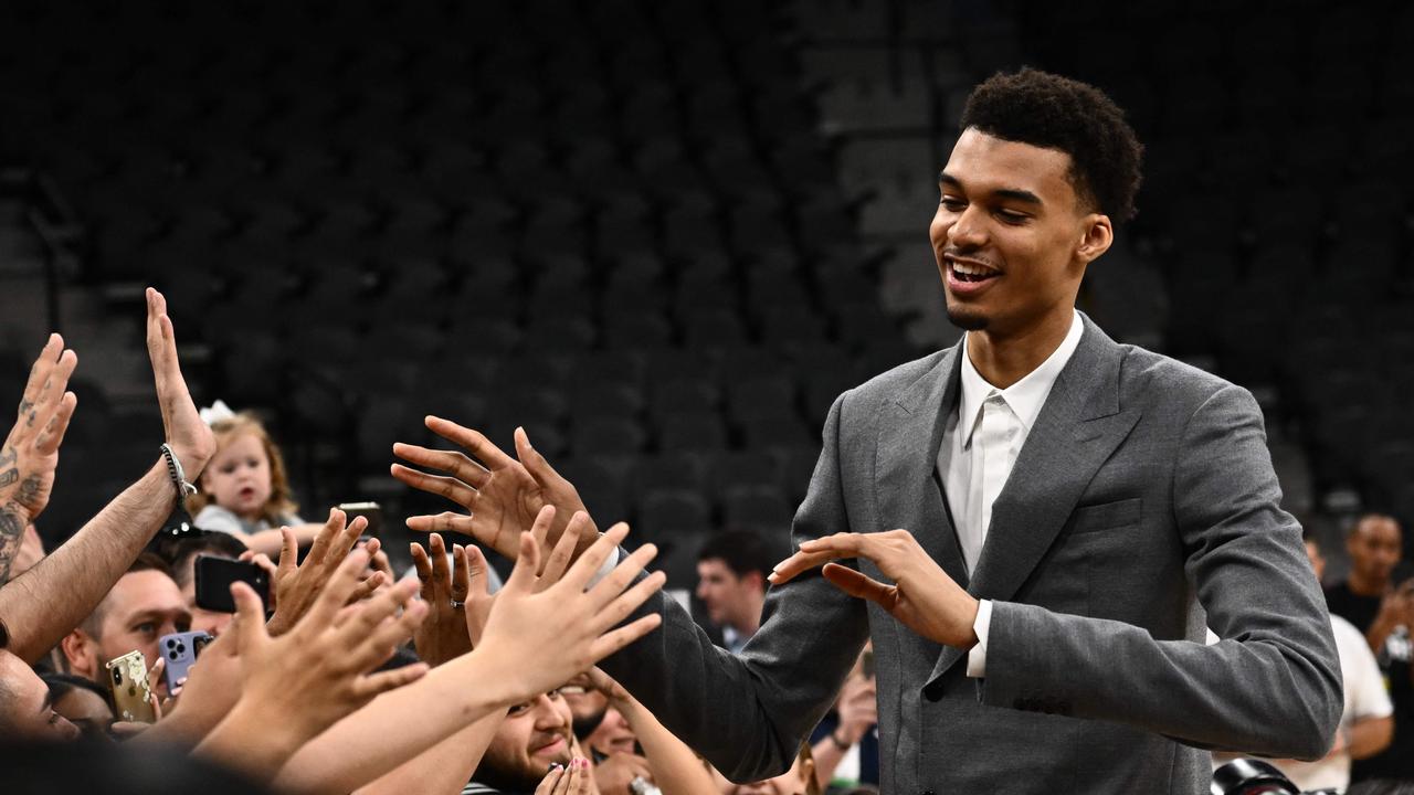 Victor Wembanyama greets the crowd during a news conference introducing the Spurs 2023 Draft Class, at the AT&amp;T Center in San Antonio, Texas. (Photo by Patrick T. Fallon / AFP)