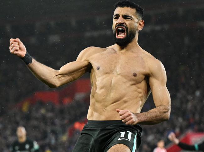 Liverpool's Egyptian striker #11 Mohamed Salah (R) celebrates after shooting a penalty kick and scoring his team third goal during the English Premier League football match between Southampton and Liverpool at St Mary's Stadium in Southampton, southern England on November 24, 2024. (Photo by JUSTIN TALLIS / AFP) / RESTRICTED TO EDITORIAL USE. No use with unauthorized audio, video, data, fixture lists, club/league logos or 'live' services. Online in-match use limited to 120 images. An additional 40 images may be used in extra time. No video emulation. Social media in-match use limited to 120 images. An additional 40 images may be used in extra time. No use in betting publications, games or single club/league/player publications. /