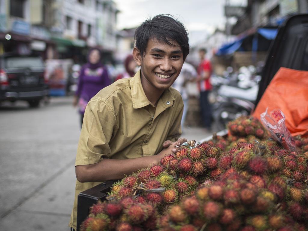 A young man delivers rambutan in Banda Aceh, Indonesia. Picture by Matt Turner.