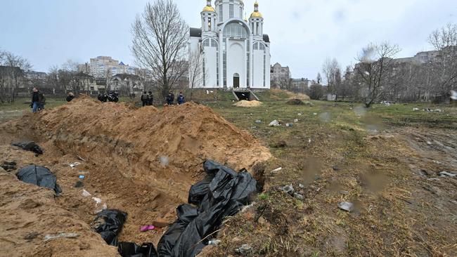 A mass grave is seen behind a church in Bucha on Sunday. Picture: AFP