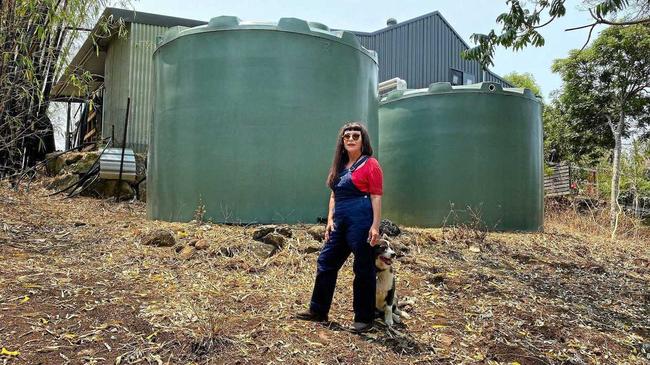 RUNNING ON EMPTY: Mishaela Simpkins, from Mullumbimby Creek, stands beside her twin 20,000 litre tanks that are all but empty due to the drought. Picture: Christian Morrow