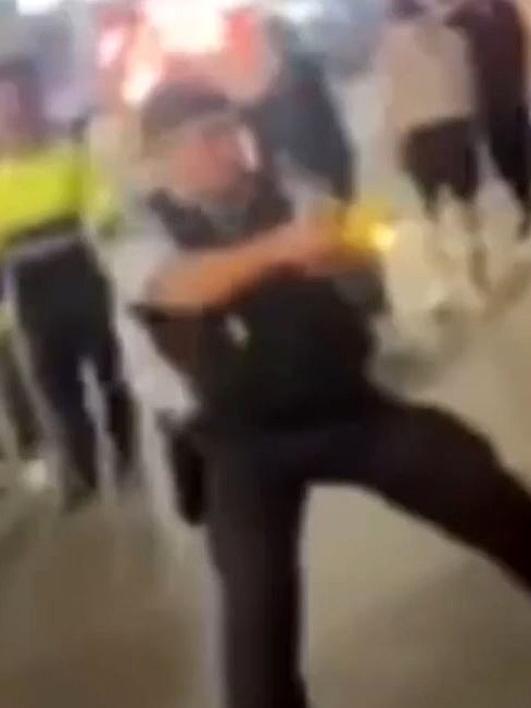 A police officers deploys a Taser to subdue one young brawler.