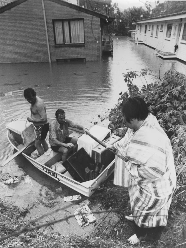 Fred Schonell Drive, St Lucia - Evacuation of residents Brian Farrell and Colin Reese help a neighbour move possessions to higher ground