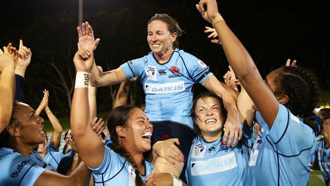 Ash Hewson and Waratahs teammates celebrate victory in the Super W grand final in April.