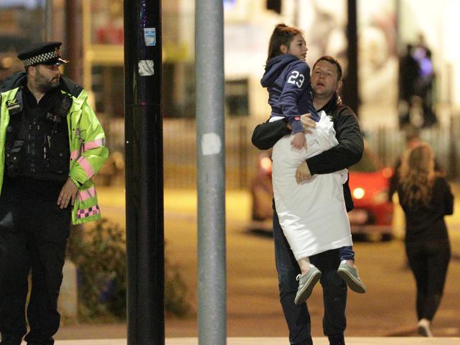 A man and girl leave Manchester Arena after the blast. Picture: Joel Goodman/LNP